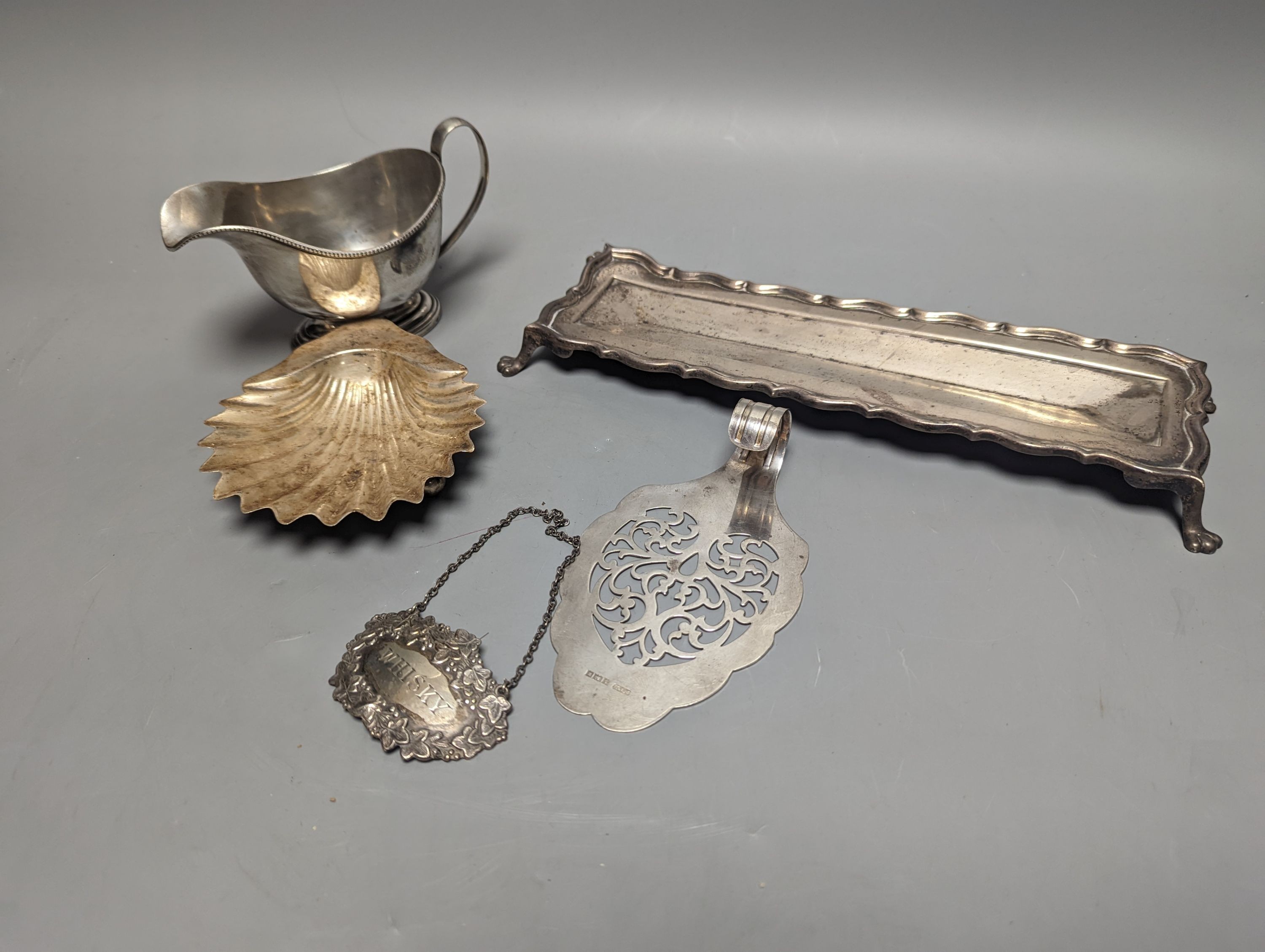 A George V silver sauceboat, an Edwardian silver pen tray and three other items including shell butter dish, 18oz.